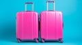 Vibrant blue background with two bright pink suitcases, travel luggage set for vacation