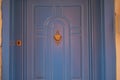 Blue front door with a brass knocker and keyhole Royalty Free Stock Photo