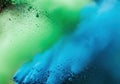 Vibrant blue and green powder explosion creating a dynamic abstract background Royalty Free Stock Photo