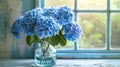 Vibrant blue hydrangeas in a glass vase on a rustic wooden table near a window