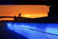 Vibrant Blue Illuminated Stone Wall Under Bridge at Sunset