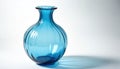 Vibrant blue ribbed glass vase sits on pristine white surface. Smooth clear form reflects light, casting subtle blue shadow. Royalty Free Stock Photo
