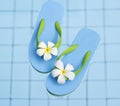 Vibrant blue sandals and flower in the water pool