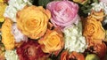 Vibrant bouquet of flowers with yellow-orange roses pink and orange buttercups white guilder roses