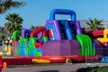 VIbrant and bright colored children`s blow up playground with slides and bouncy castle  at a street festival for outdoor fun in Royalty Free Stock Photo