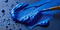 A vibrant burst of royal blue pigment gracefully spread on a glossy surface