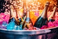 Vibrant champagne bottles nestled among colorful glowing ice, with shimmering droplets in the backdrop. Royalty Free Stock Photo