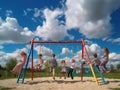 Friends swinging on colorful swings under blue sky