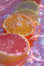 Vibrant Citrus Slices with Refreshing Water Droplets on Colorful Liquid Background