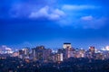 Vibrant city lit up at night beneath cloudy weather