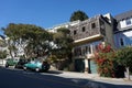 Vibrant city street featuring residential dwellings and parked vehicles