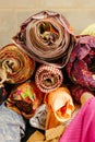 Vibrant collection of multicolored fabric rolls and swatches, arranged in a neat pile