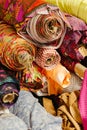 Vibrant collection of multicolored fabric rolls and swatches, arranged in a neat pile