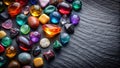 A vibrant collection of polished gemstones, showcasing a diverse array of colors, shapes, and textures, rests on a dark slate Royalty Free Stock Photo
