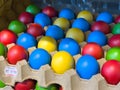 Vibrant yellow blue colored eggs in carton display Royalty Free Stock Photo