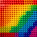 Vibrant and colorful background composed entirely of interlocking plastic construction blocks arranged in a smooth rainbow Royalty Free Stock Photo