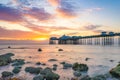 Vibrant colorful sunrise over the rugged rocky coastline with Llandudno Pier in the background - North Wales Royalty Free Stock Photo