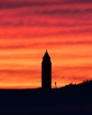 Vibrant colorful sunset sky behind the silhouette of a pencil water tower on the beach. Fire Island