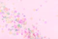 Vibrant confetti on pastel pink background