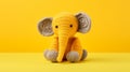 Vibrant Crochet Elephant: A Playful Touch Of Color On A Yellow Canvas