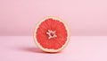 A vibrant cross-section of a grapefruit on a clean pink background captures simplicity and health Royalty Free Stock Photo