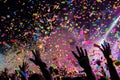 A vibrant crowd at a concert enthusiastically revels amidst a deluge of confetti and streamers, A burst of confetti rains down on Royalty Free Stock Photo