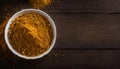 Vibrant Curry Powder in a White Bowl on Rustic Wooden Table, Copy Space Royalty Free Stock Photo