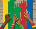 Diverse group of children\'s hands reaching towards colorful puzzle pieces on a wooden background Royalty Free Stock Photo