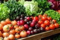 A vibrant display of fresh and colorful vegetables at a market stall, showing the variety of organic lettuces, tomatoes and