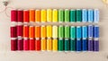 Rainbow Thread Spools arranged in Rainbow Gradient on Craft Table Royalty Free Stock Photo