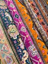 A vibrant display of traditional ethnic textiles, showcasing an array of intricate patterns, bold colors, and decorative