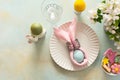A vibrant Easter table setting features a beautifully arranged plate with a wrapped egg, decorated cookies, and fresh Royalty Free Stock Photo