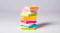 A vibrant and eye-catching image of a stack of multicolored sticky notes on a clean white background. The notes are in