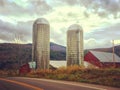 Vibrant farm scene in rural Vermont with a bright red barn and two white silos Royalty Free Stock Photo