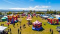 Vibrant Festival Setting with Inflatable Bouncers and Vendors.