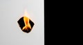 Flame burning through paper hole on white background Royalty Free Stock Photo