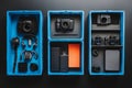 A vibrant flat lay of three blue containers brimming with an array of tech gadgets, showcasing modern technology essentials Royalty Free Stock Photo
