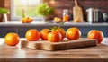 A selection of fresh fruit: mandarines, sitting on a chopping board against blurred kitchen background copy space