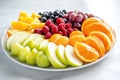 Vibrant fruit platter with berries, apples, and citrus slices on marble surface Royalty Free Stock Photo