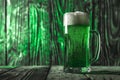 Vibrant green beer in a glass on a wooden table Royalty Free Stock Photo
