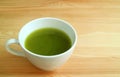 Vibrant Green Color a Cup of Hot Matcha Green Tea Isolated on Natural Brown Wooden Table