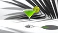 Vibrant green martini with lime slice on a white surface, contrasting with dramatic black and white palm leaf shadows Royalty Free Stock Photo