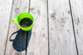 Vibrant green plastic  cup with shadow  filled with coffee on aged pine wood table Royalty Free Stock Photo