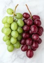 Vibrant green and red grapes on a marble background Royalty Free Stock Photo