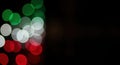 Vibrant green, white, and red bokeh lights create an abstract festive background against a dark backdrop, offering ample copy Royalty Free Stock Photo
