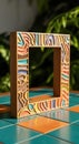 Vibrant Hand-Painted Wooden Frame with Abstract Patterns on Tiled Surface Royalty Free Stock Photo