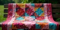 Vibrant handmade quilt draped on a rustic wooden bench, displaying intricate patchwork and textured stitching in a garden setting Royalty Free Stock Photo