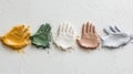 Vibrant handprints in various paint colors on textured white surface Royalty Free Stock Photo