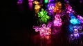 Vibrant Illuminated Bunny String Lights on Wooden Surface in Dark Ambiance. Easter garland