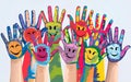 A vibrant illustration showcasing multiple handprints painted in various colors, each featuring a smiling face. The handprints are Royalty Free Stock Photo